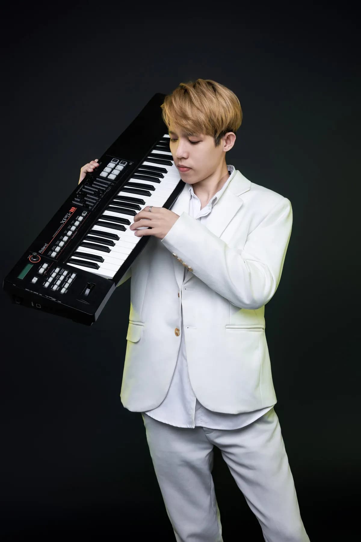 Keyboardist in a white suit holding his keyboard