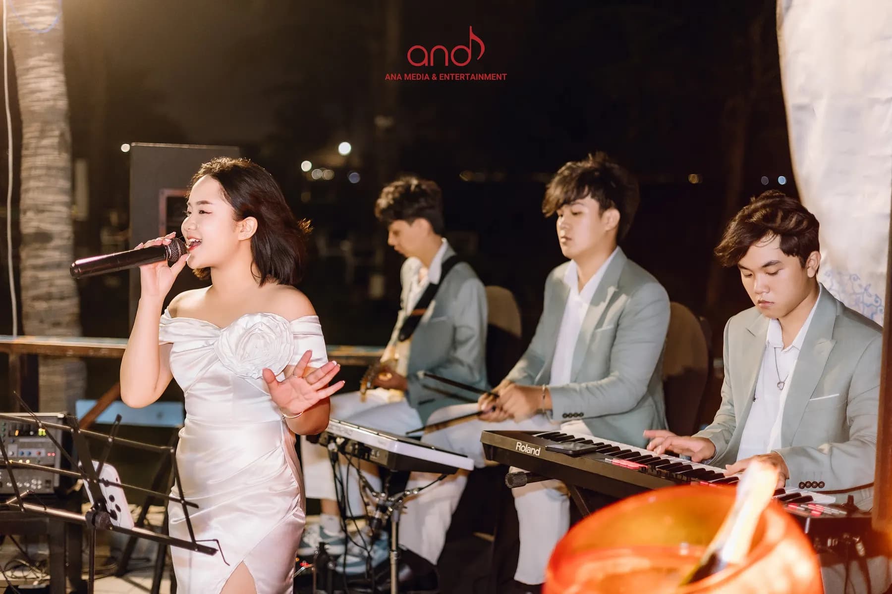 Singer and band playing an outdoor night show