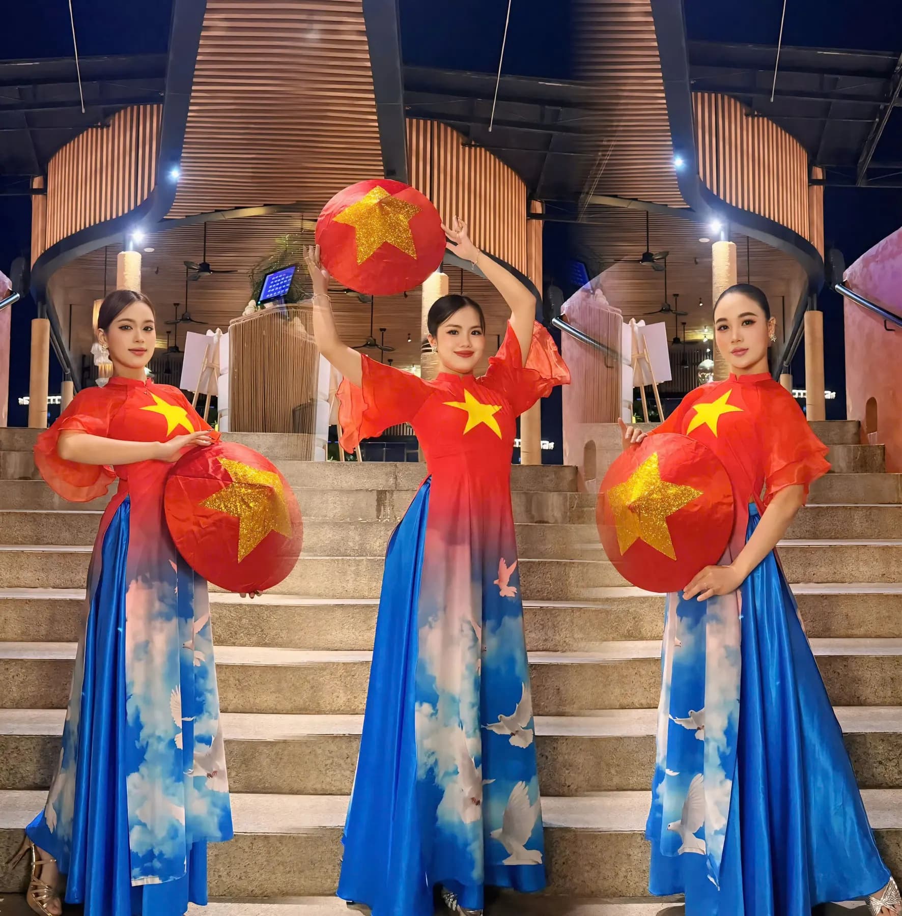 Three dancers with red fans bearing a gold star