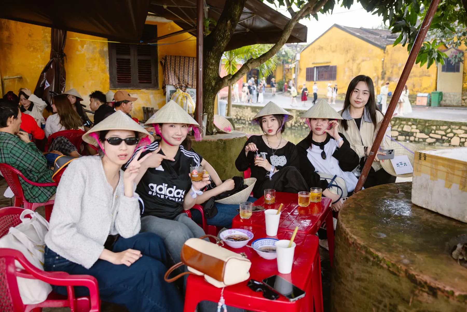 Guests in conical hats at a street-side café in Hoi An old town