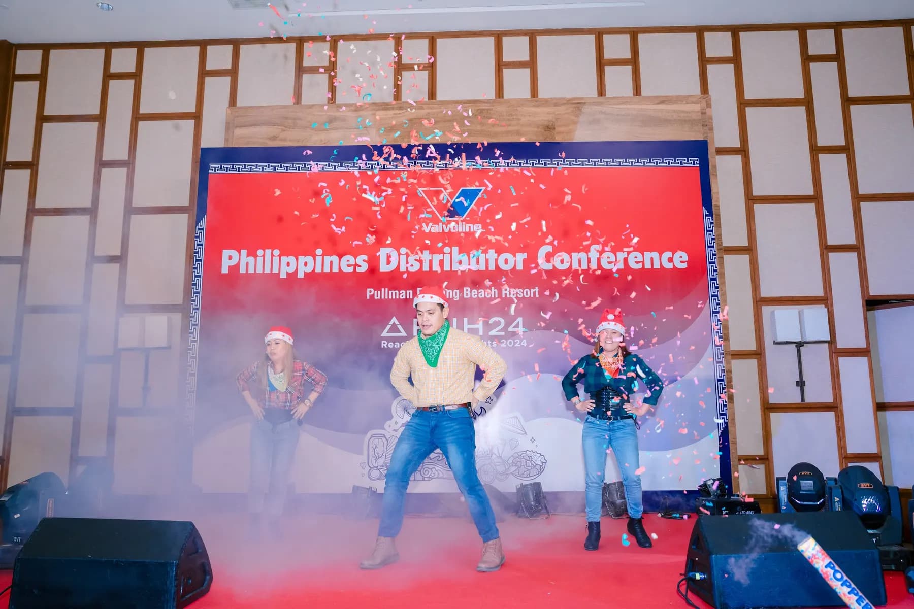 Dancers in western outfits on stage under confetti and smoke