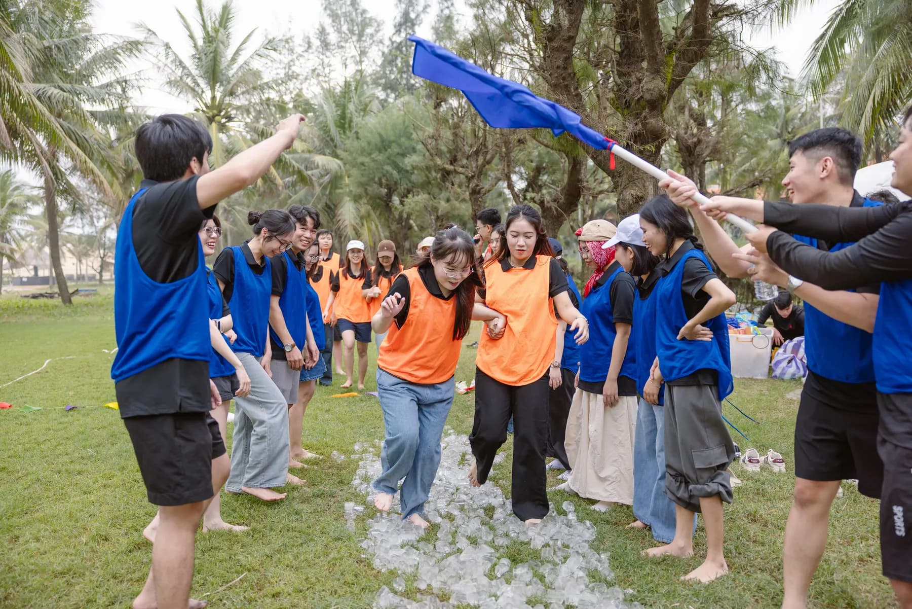 Teams racing barefoot through a flag relay