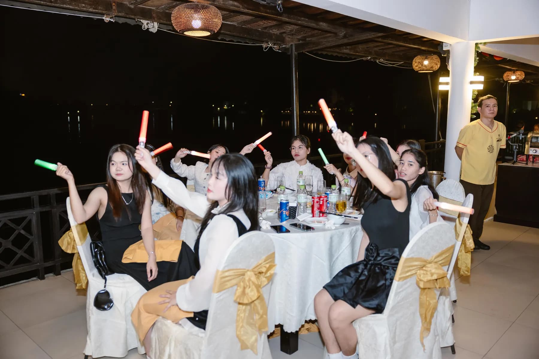 Guests waving light sticks at their table