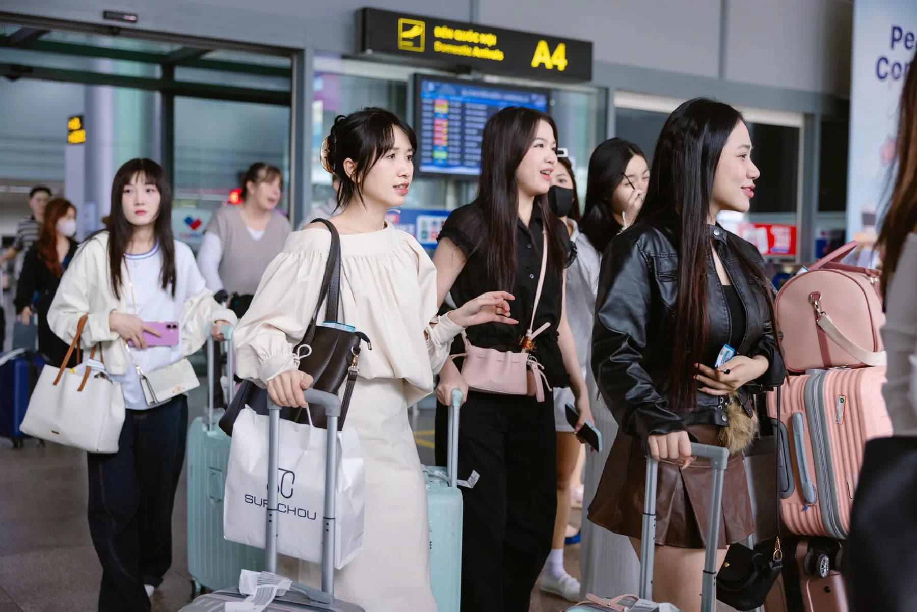 Tour group with suitcases leaving the domestic arrivals hall at the airport